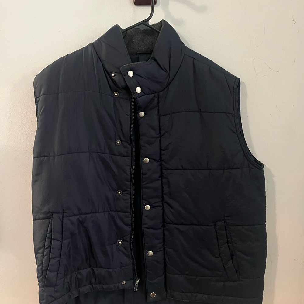 Sleeveless dark navy blue puffy coat.